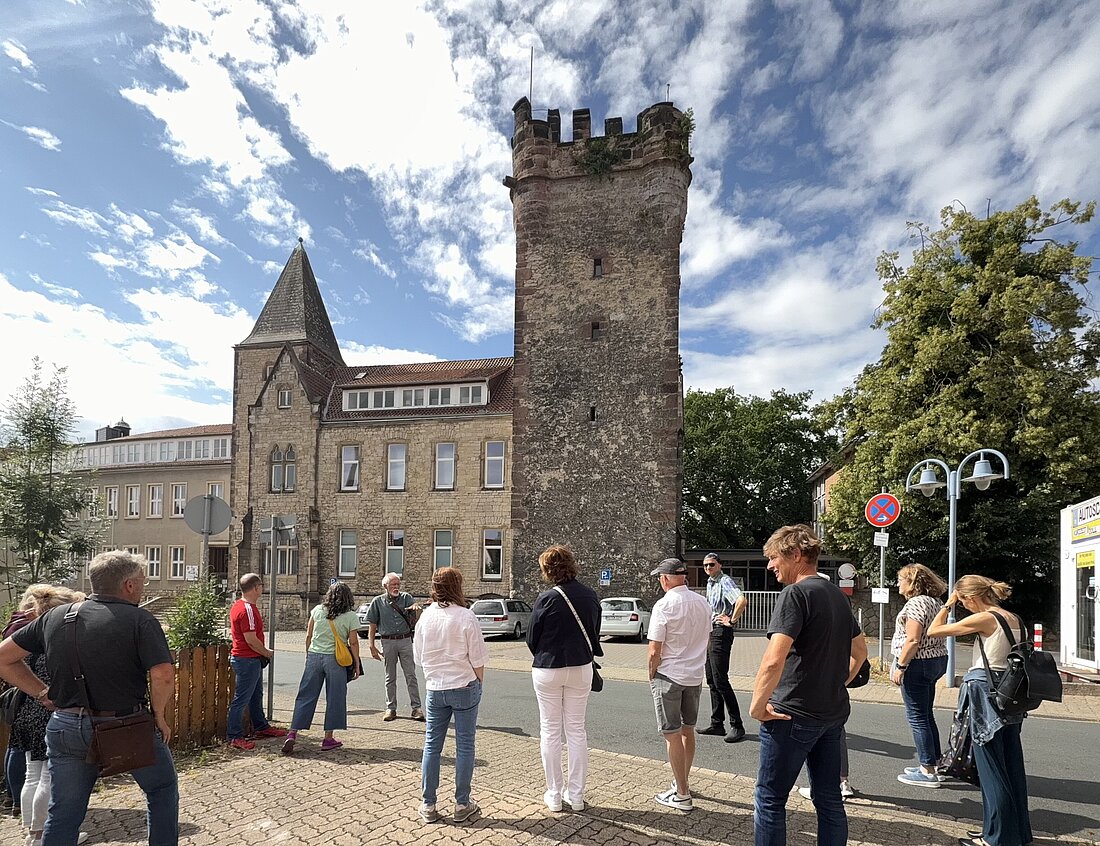 Der Fillerturm ist Alfeld ist ein Ziel der Stadtführungen. Hier sieht man eine Gruppe vor dem Turm bei herrlich weiss-blauem Himmel. © hgscharf