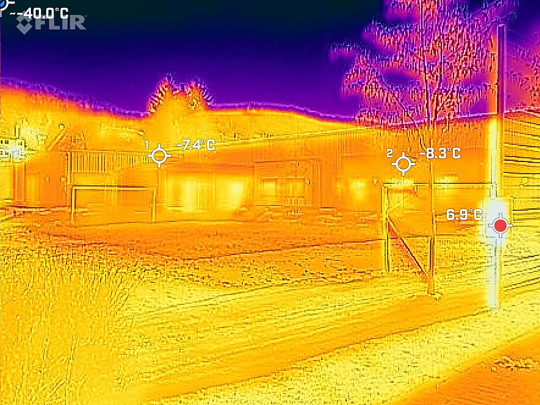 Eine Aufnahme der Hörsumer Kindertagesstätte mit einer Wärmebildkamera aufgenommen. Man sieht das Gebäudes vor einem dunkelblauen Hintergrund in orangenen Farben. 